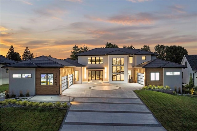 view of front of home with a garage and a lawn