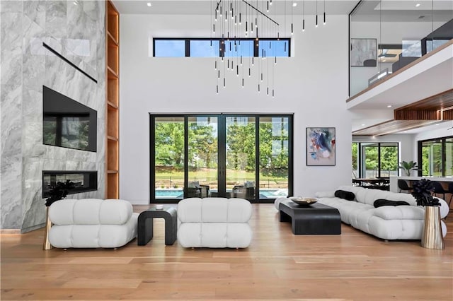 living room featuring a fireplace, a high ceiling, and a wealth of natural light