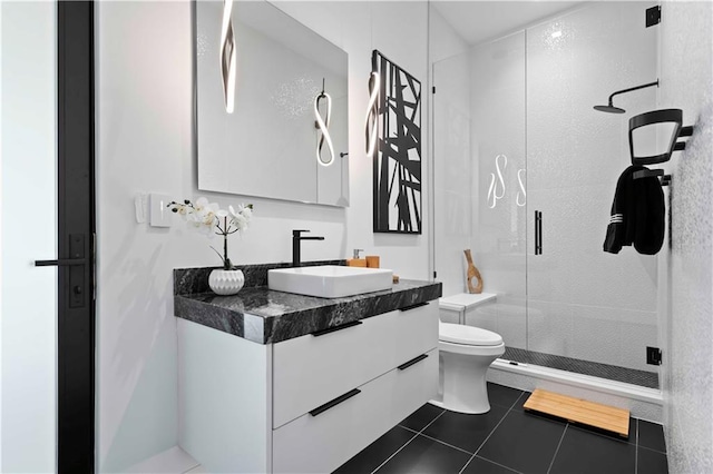 bathroom featuring tile patterned flooring, vanity, toilet, and an enclosed shower