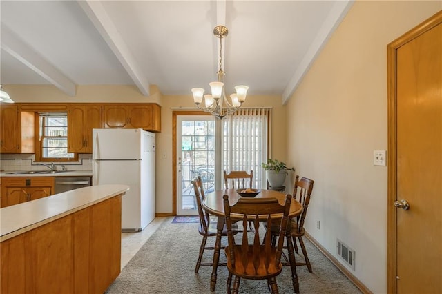 dining area with an inviting chandelier, baseboards, visible vents, and beam ceiling