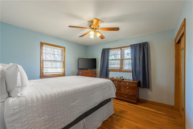 bedroom featuring ceiling fan, a closet, and wood finished floors