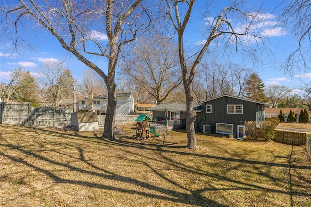 view of yard with a playground, cooling unit, and fence