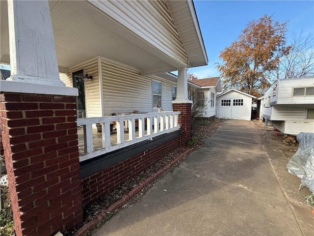 view of side of property with covered porch and an outbuilding