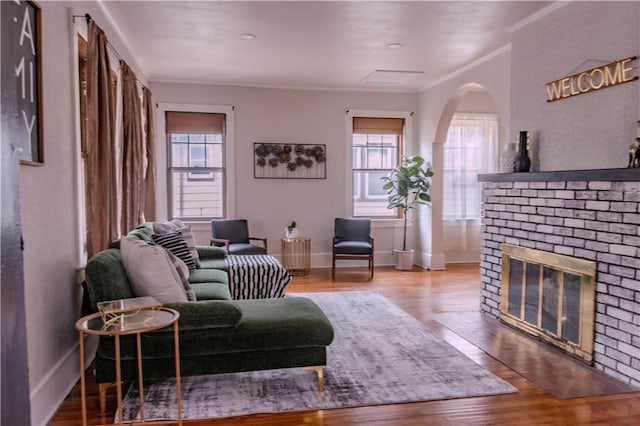 living room with crown molding, a fireplace, and hardwood / wood-style floors