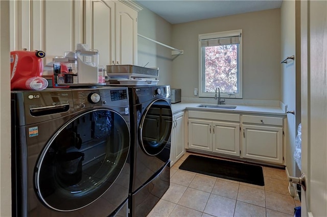 washroom featuring cabinets, light tile patterned floors, washer and clothes dryer, and sink