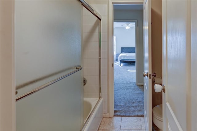 bathroom featuring tile patterned floors, toilet, and shower / bath combination with glass door