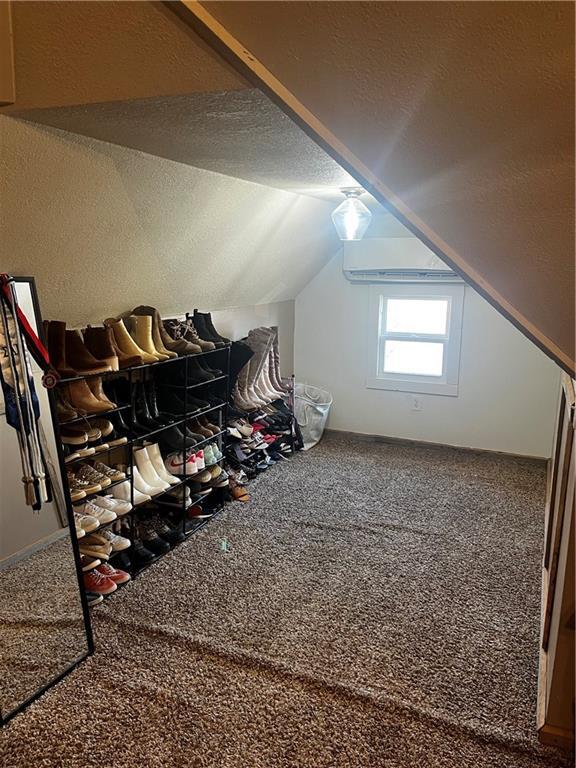 bonus room featuring carpet flooring, a textured ceiling, and vaulted ceiling