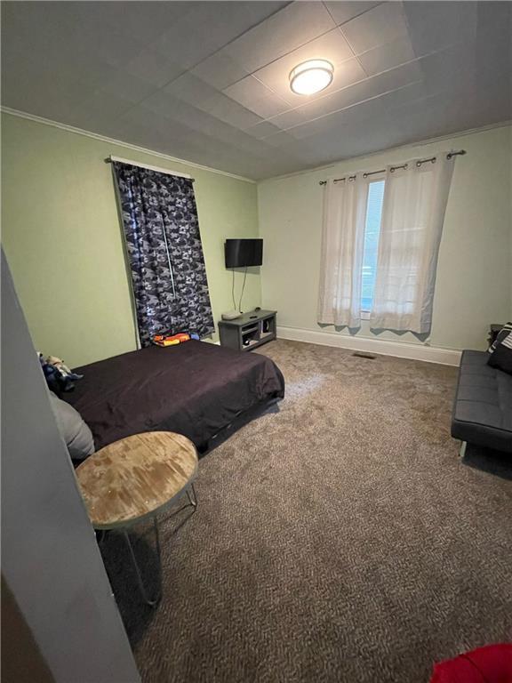 carpeted bedroom featuring ornamental molding