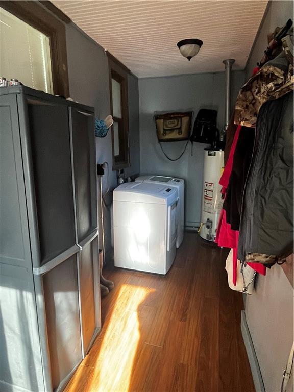 laundry room featuring washing machine and dryer, water heater, and wood-type flooring