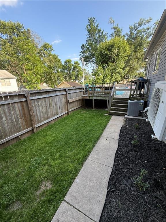 323 W 6th St, Chanute, KS 66720 - view of yard featuring a wooden deck, central AC, and a cooling unit