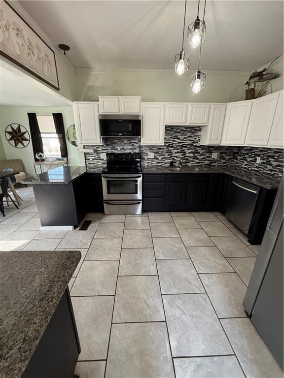 323 W 6th St, Chanute, KS 66720 - kitchen featuring appliances with stainless steel finishes, dark stone counters, decorative backsplash, and a peninsula