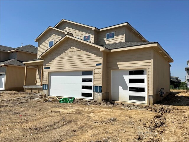 view of front of house with a shingled roof and a garage
