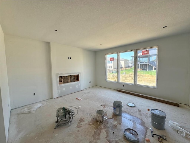 unfurnished living room with a fireplace and a textured ceiling