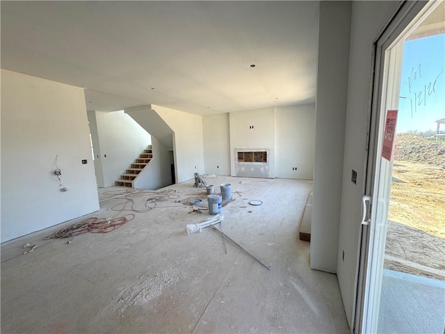 unfurnished living room featuring stairs