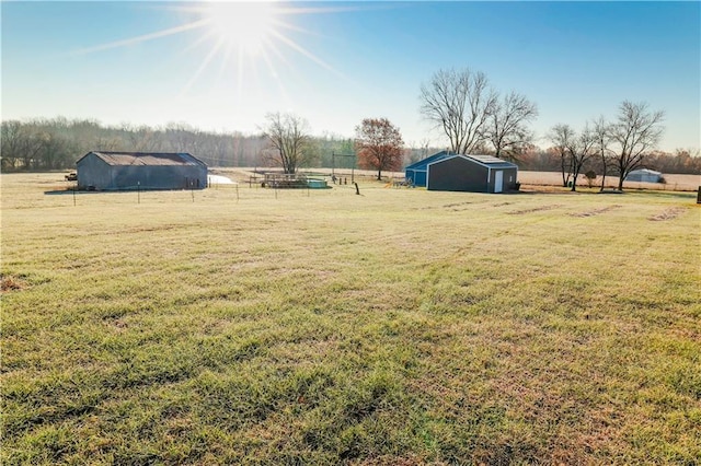 view of yard with an outbuilding and a rural view