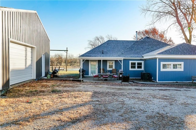 back of house featuring a patio area, a garage, and an outdoor structure