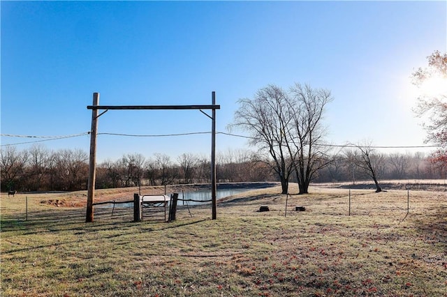 view of community with a rural view, a yard, and a water view