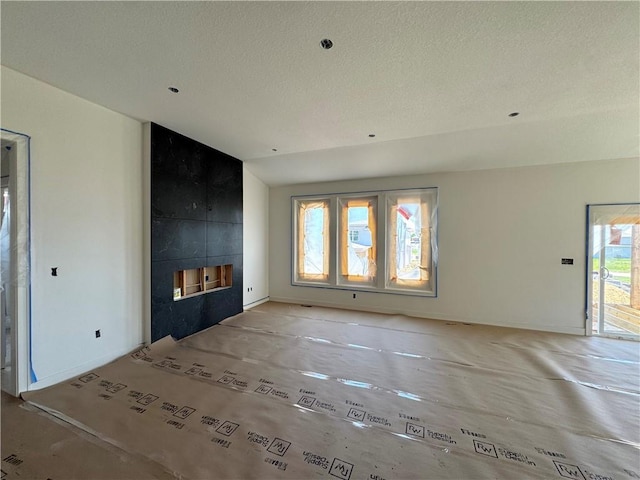 unfurnished living room featuring lofted ceiling and a textured ceiling