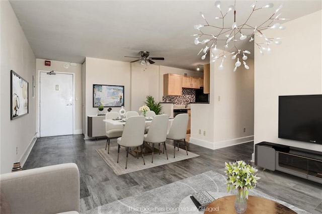 dining space featuring ceiling fan with notable chandelier and dark wood-type flooring