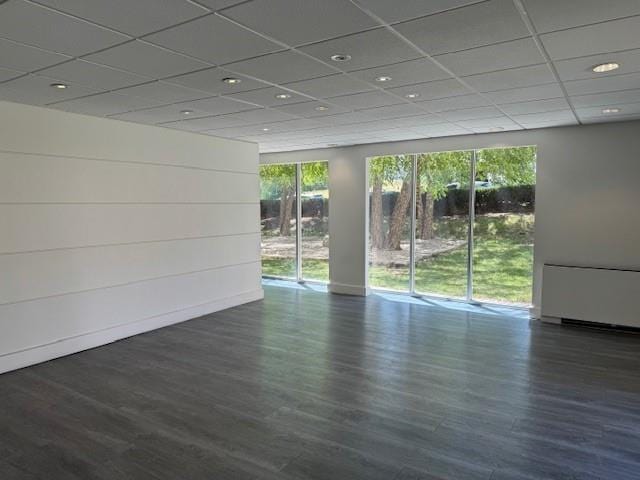 unfurnished room featuring a drop ceiling and dark hardwood / wood-style flooring