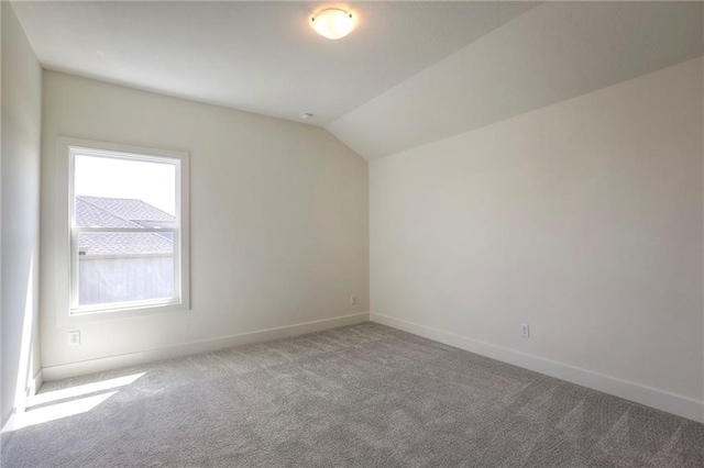 additional living space featuring carpet flooring and vaulted ceiling