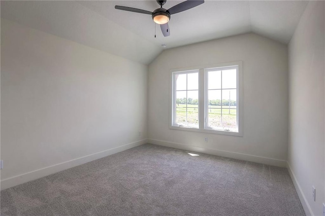 spare room featuring carpet flooring, ceiling fan, and vaulted ceiling