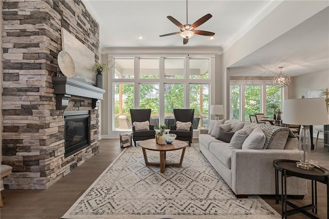 living room with plenty of natural light, dark hardwood / wood-style flooring, ornamental molding, and a fireplace