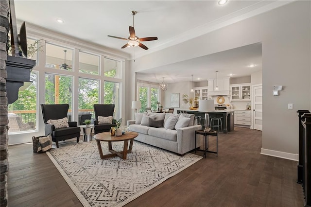 living room with a wealth of natural light, dark wood-type flooring, and ceiling fan