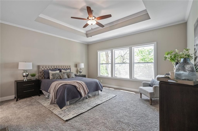 carpeted bedroom with a raised ceiling, ceiling fan, and ornamental molding