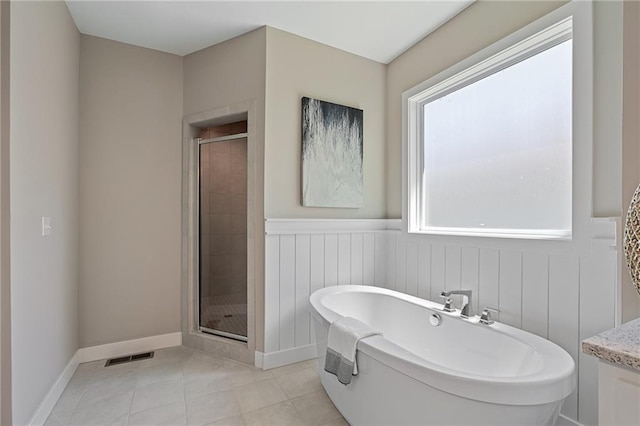 bathroom featuring tile patterned flooring, independent shower and bath, and a healthy amount of sunlight