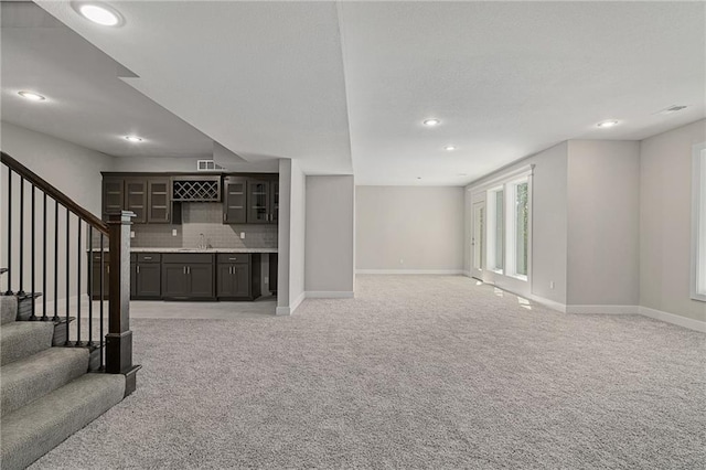 living room featuring wet bar and light colored carpet