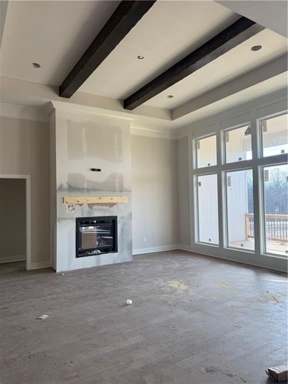 unfurnished living room featuring recessed lighting, baseboards, a fireplace, and beamed ceiling