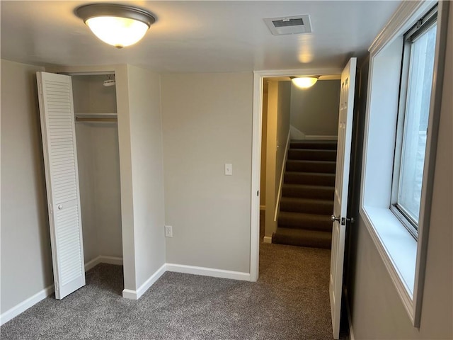 unfurnished bedroom featuring a closet and dark colored carpet