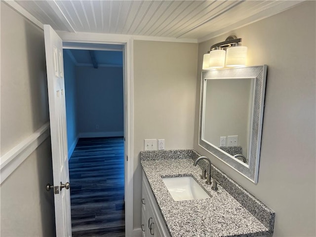 bathroom featuring vanity, hardwood / wood-style flooring, and crown molding