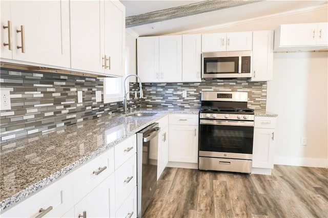 kitchen with white cabinetry, sink, tasteful backsplash, vaulted ceiling with beams, and appliances with stainless steel finishes