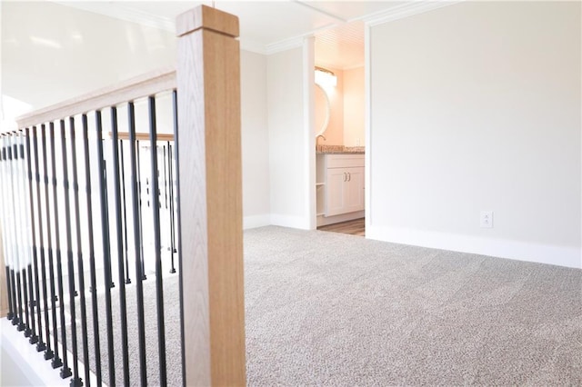 corridor with crown molding and light carpet