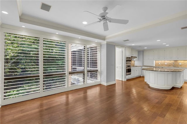 433 Ward Pkwy Unit 3S, Kansas City, MO 64112 - kitchen featuring crown molding, ceiling fan, white cabinetry, backsplash, and hardwood / wood-style floors
