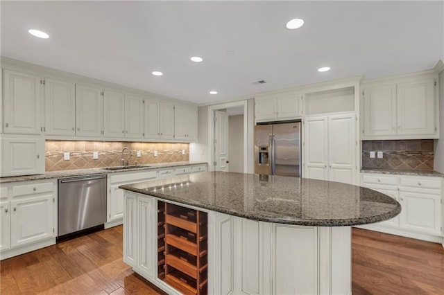 433 Ward Pkwy Unit 3S, Kansas City, MO 64112 - kitchen with stainless steel appliances, beverage cooler, dark wood finished floors, tasteful backsplash, and white cabinetry