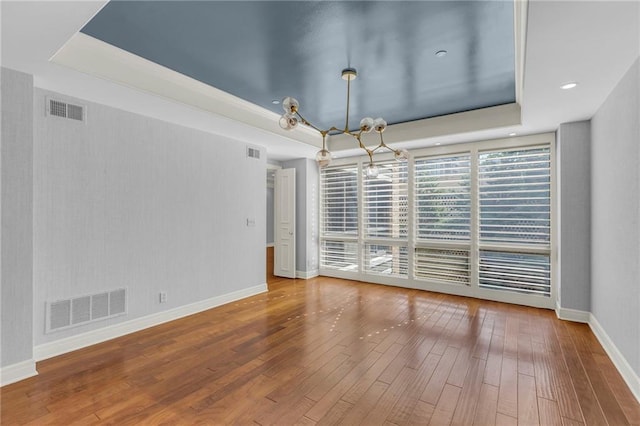 433 Ward Pkwy Unit 3S, Kansas City, MO 64112 - unfurnished room with a raised ceiling, wood-type flooring, and a chandelier