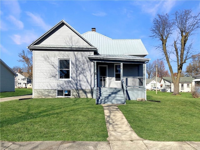 bungalow-style home featuring covered porch and a front yard