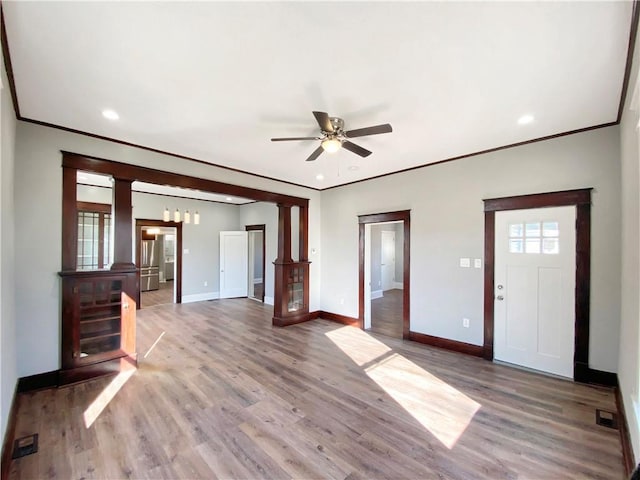 unfurnished living room featuring hardwood / wood-style flooring, ceiling fan, ornamental molding, and decorative columns