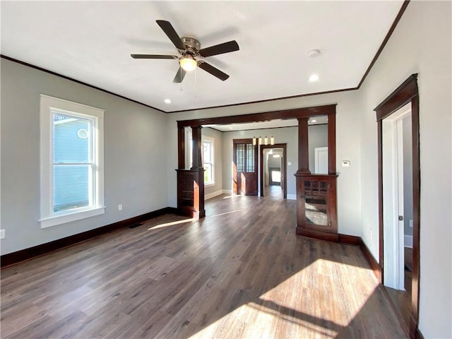 unfurnished living room featuring ceiling fan, dark hardwood / wood-style flooring, and decorative columns