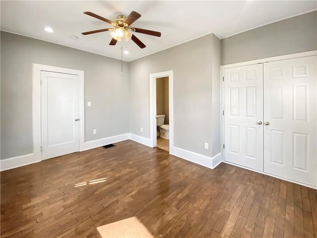 unfurnished bedroom featuring dark hardwood / wood-style flooring, ceiling fan, and connected bathroom