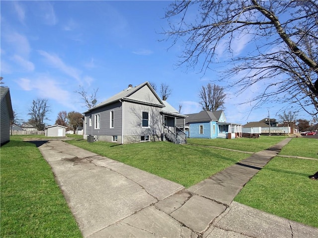 back of house with a garage, an outdoor structure, and a lawn