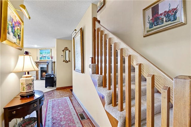 stairway featuring a textured ceiling