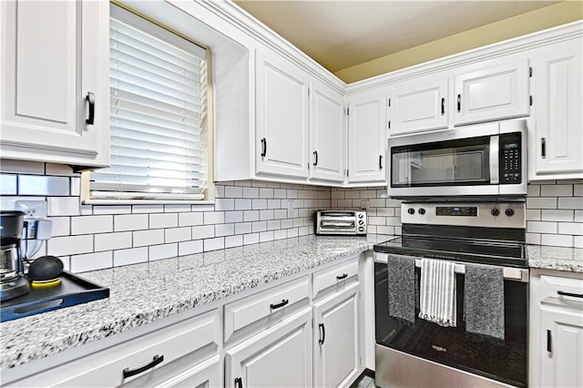 kitchen featuring decorative backsplash, white cabinetry, and appliances with stainless steel finishes