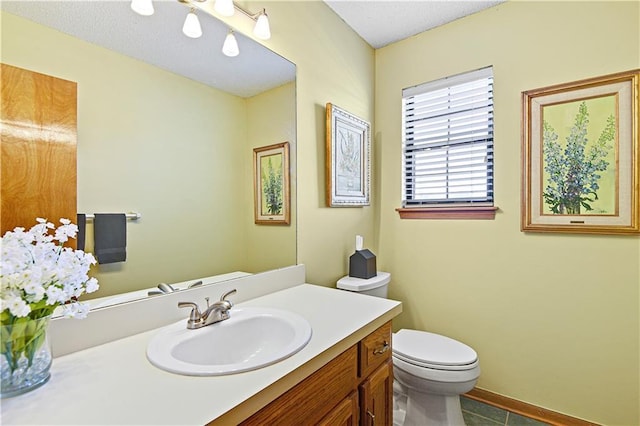 bathroom featuring tile patterned floors, vanity, and toilet