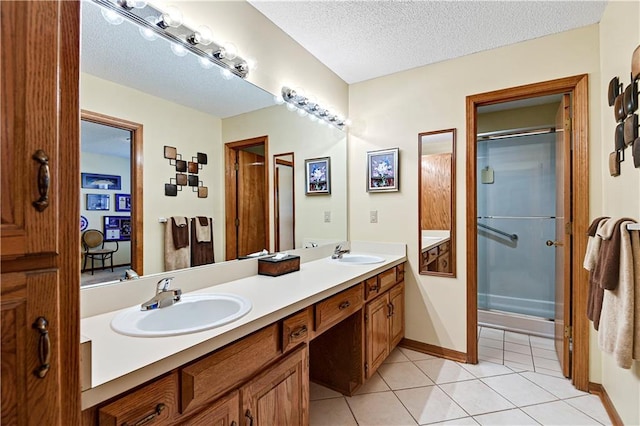 bathroom featuring tile patterned flooring, vanity, a shower with shower door, and a textured ceiling