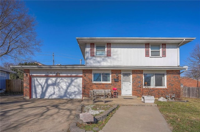 view of front of home with brick siding, concrete driveway, fence, and a garage