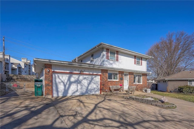 view of front facade with driveway, brick siding, an attached garage, and fence